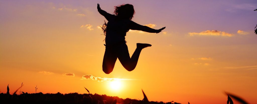 Person leaping in front of sun