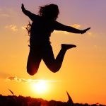 Person leaping in front of sun
