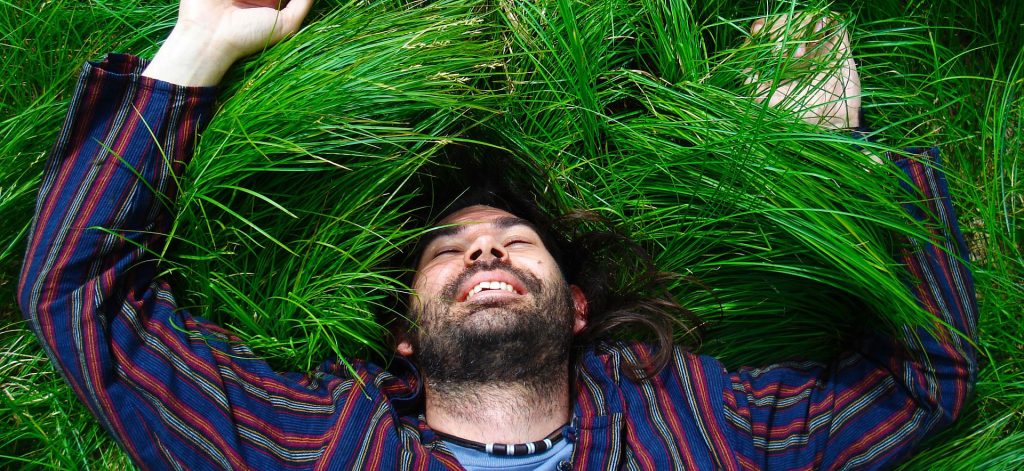 Happy man laying in grass