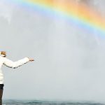 Lady in front of rainbow